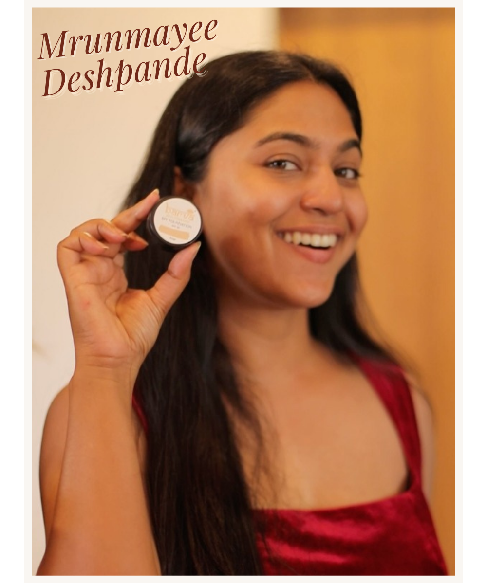 Smiling woman in red dress holding organic beauty cream in natural indoor light
